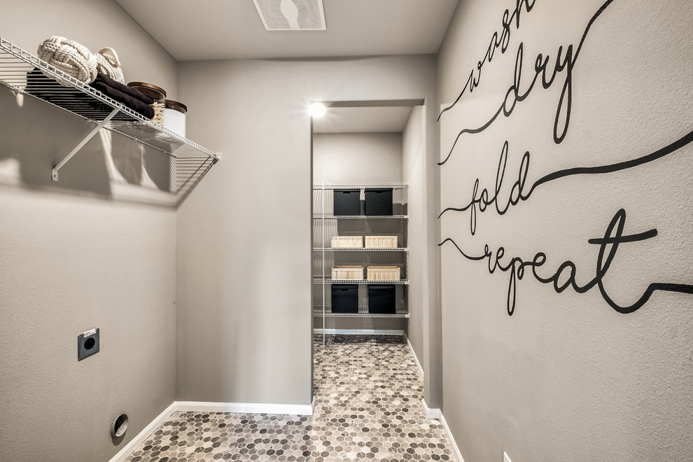 Lantlig inredning av ett mellanstort parallellt grovkök, med beige väggar, laminatgolv, en tvättmaskin och torktumlare bredvid varandra och grått golv