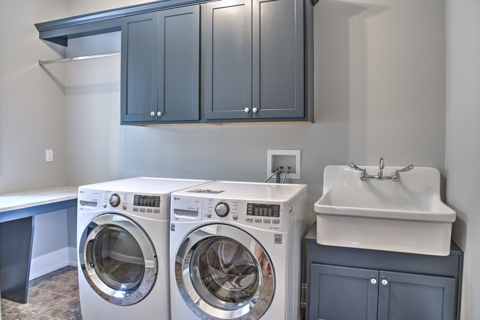 Immagine di una sala lavanderia american style di medie dimensioni con lavello stile country, ante con riquadro incassato, ante grigie, top in quarzite e lavatrice e asciugatrice affiancate
