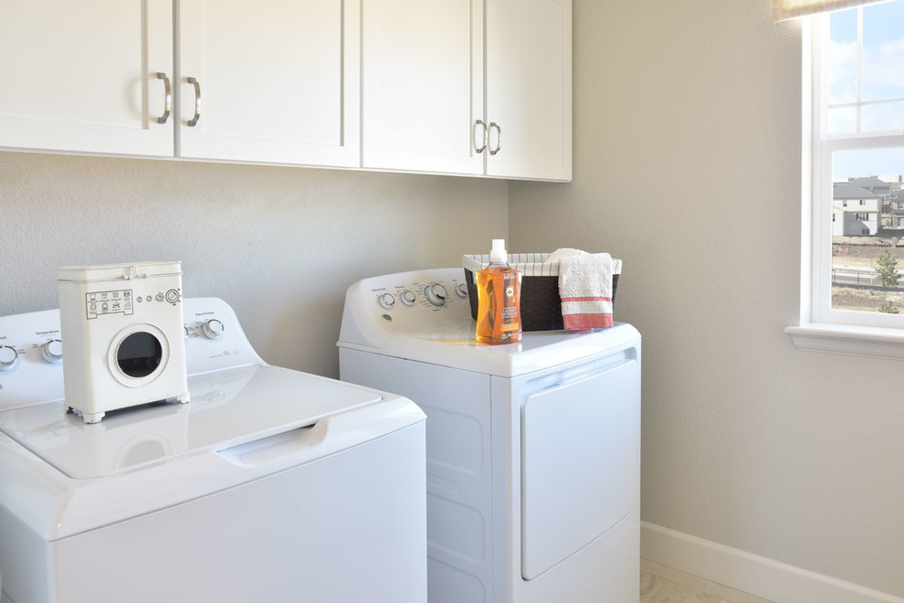 Moderne Waschküche mit weißen Schränken und Waschmaschine und Trockner nebeneinander in Denver