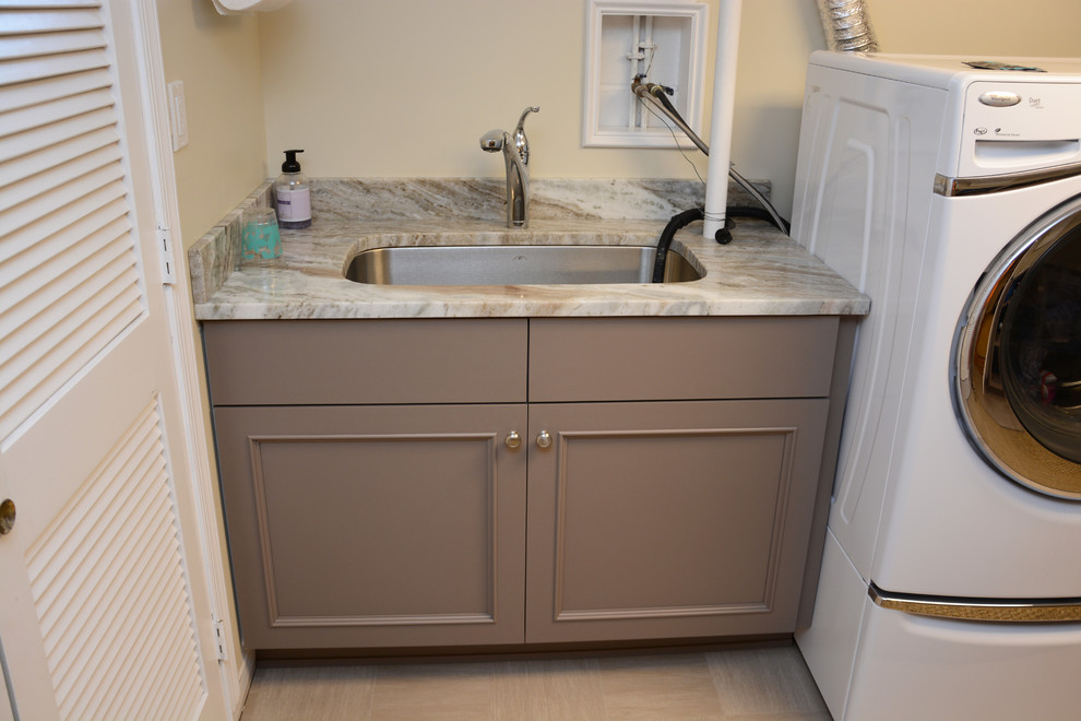 Photo of a large classic l-shaped separated utility room in Baltimore with a single-bowl sink, recessed-panel cabinets, grey cabinets, granite worktops, white walls and a side by side washer and dryer.