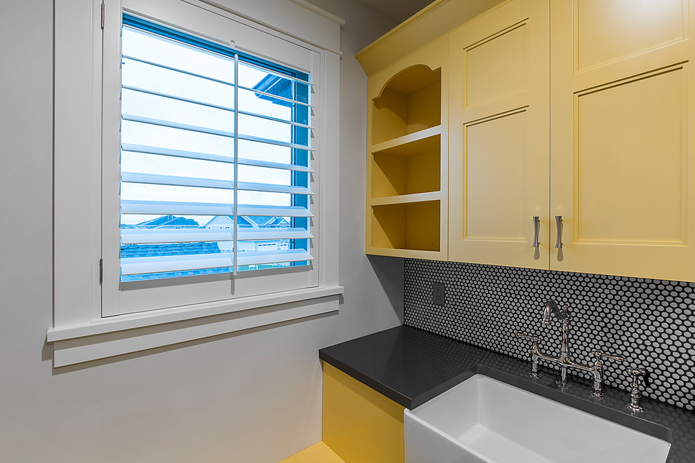 Inspiration for a cottage laundry room remodel in Salt Lake City with a farmhouse sink, recessed-panel cabinets, yellow cabinets and gray walls