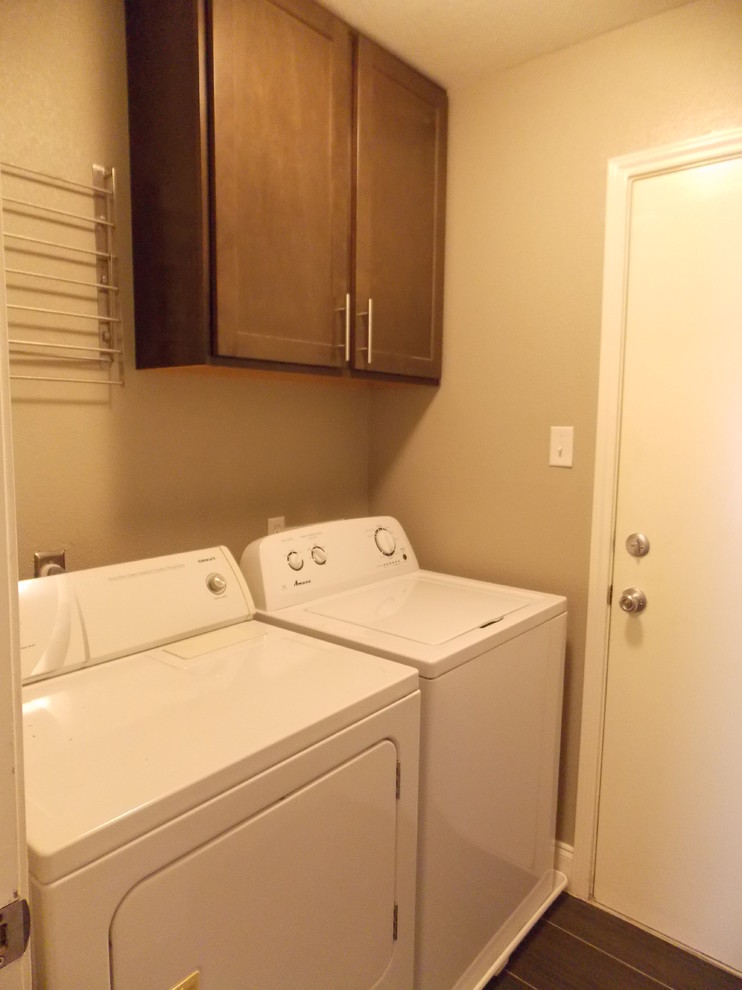 Modelo de cuarto de lavado de galera contemporáneo pequeño con armarios con paneles lisos, puertas de armario grises, paredes grises, suelo de baldosas de porcelana y lavadora y secadora juntas