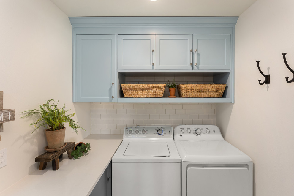 Idee per una piccola sala lavanderia design con ante in stile shaker, ante blu, top in superficie solida, pareti bianche, pavimento in gres porcellanato, lavatrice e asciugatrice affiancate, pavimento grigio e top bianco