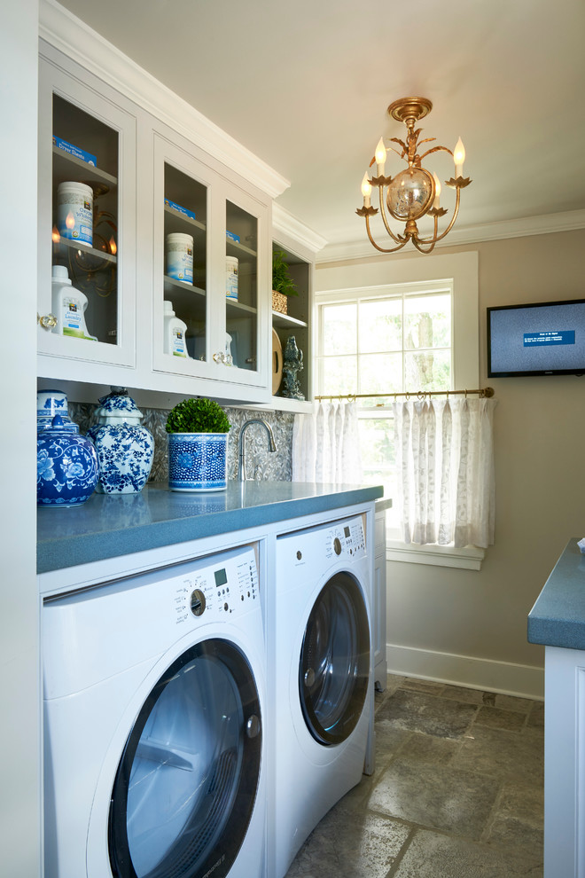 Inspiration för stora klassiska l-formade blått tvättstugor enbart för tvätt, med öppna hyllor, vita skåp, bänkskiva i koppar, beige väggar, travertin golv och en tvättmaskin och torktumlare bredvid varandra