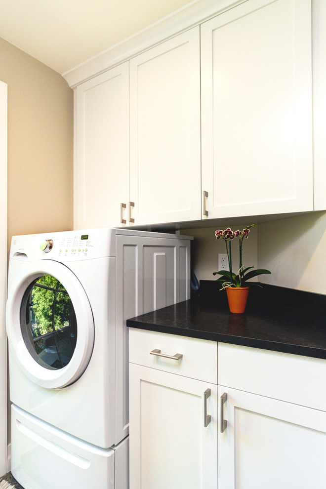 Idéer för att renovera en mellanstor vintage tvättstuga enbart för tvätt, med en undermonterad diskho, skåp i shakerstil, vita skåp, granitbänkskiva, grå väggar, linoleumgolv, tvättmaskin och torktumlare byggt in i ett skåp och grått golv