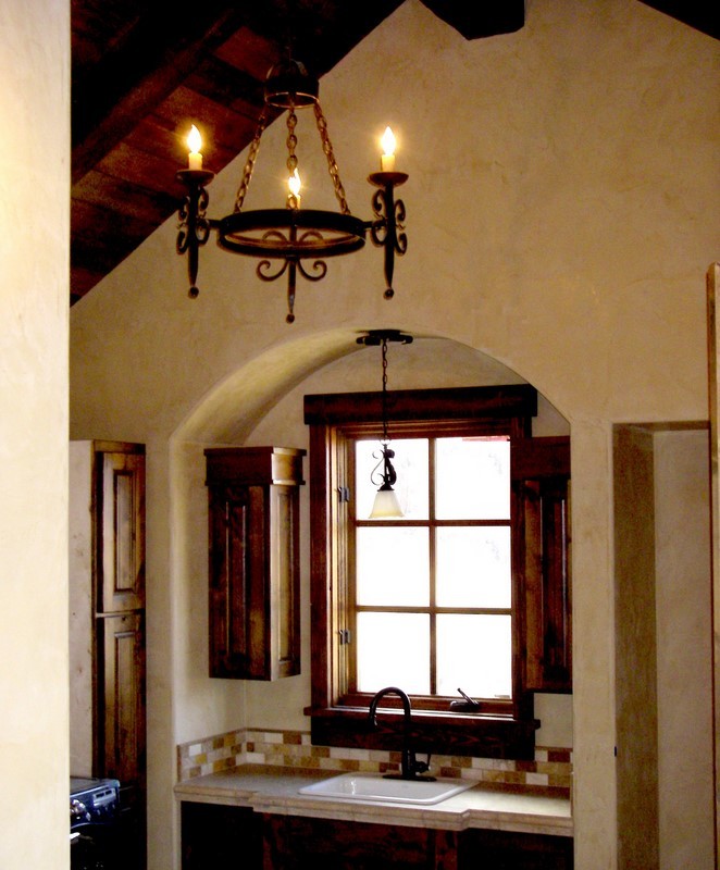 Esempio di una sala lavanderia stile rurale di medie dimensioni con lavello da incasso, ante con bugna sagomata, ante in legno bruno, pareti beige e lavatrice e asciugatrice affiancate