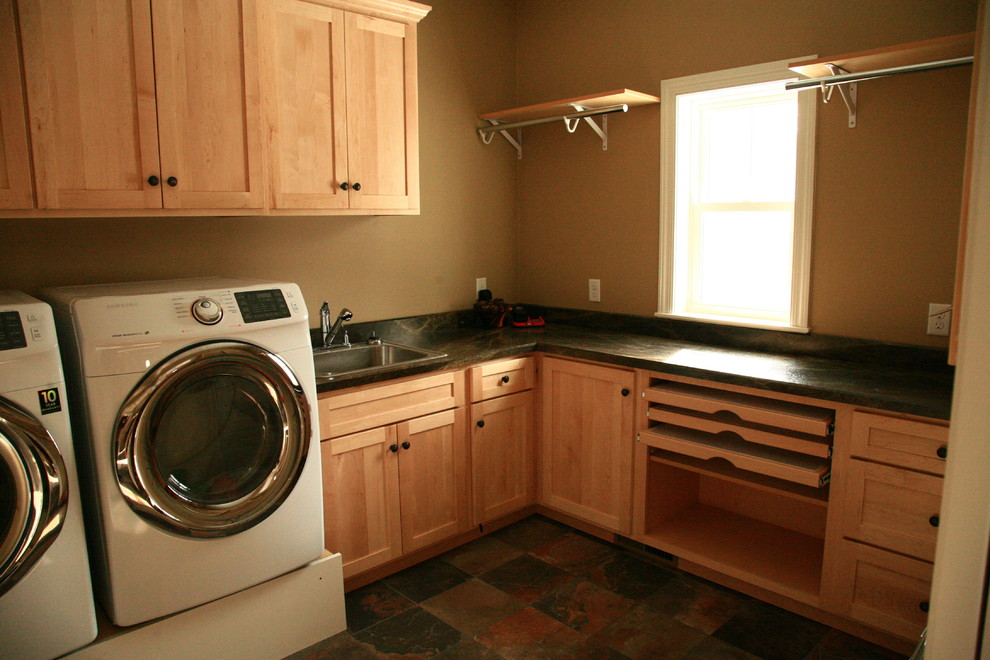 Dedicated laundry room - large modern l-shaped travertine floor dedicated laundry room idea in Other with a drop-in sink, shaker cabinets, light wood cabinets, granite countertops, beige walls and a side-by-side washer/dryer