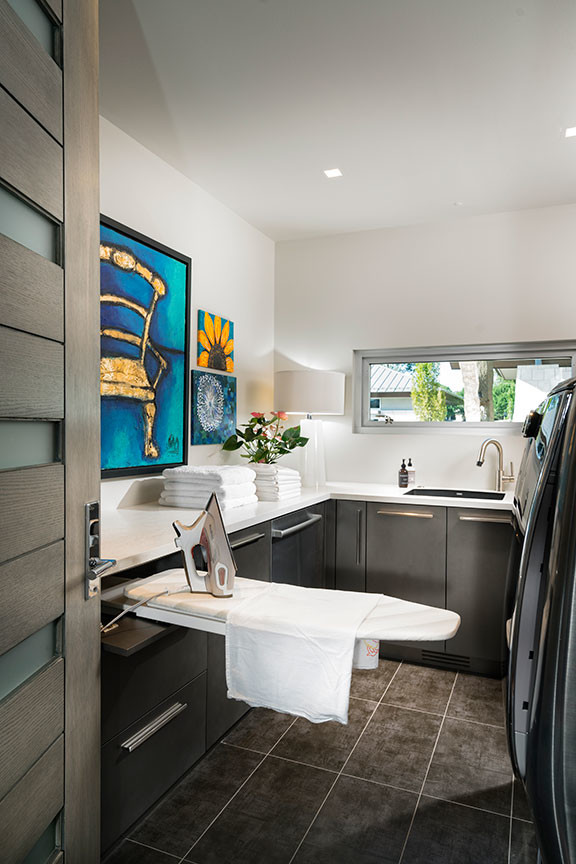 Dedicated laundry room - contemporary galley dedicated laundry room idea in Other with an undermount sink, flat-panel cabinets, brown cabinets, quartzite countertops, gray walls, a side-by-side washer/dryer and white countertops