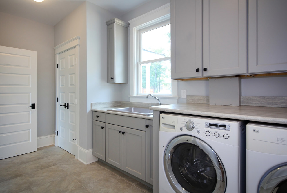 Exempel på en mellanstor lantlig linjär tvättstuga enbart för tvätt, med en nedsänkt diskho, luckor med infälld panel, grå skåp, bänkskiva i koppar, grå väggar, klinkergolv i keramik och en tvättmaskin och torktumlare bredvid varandra