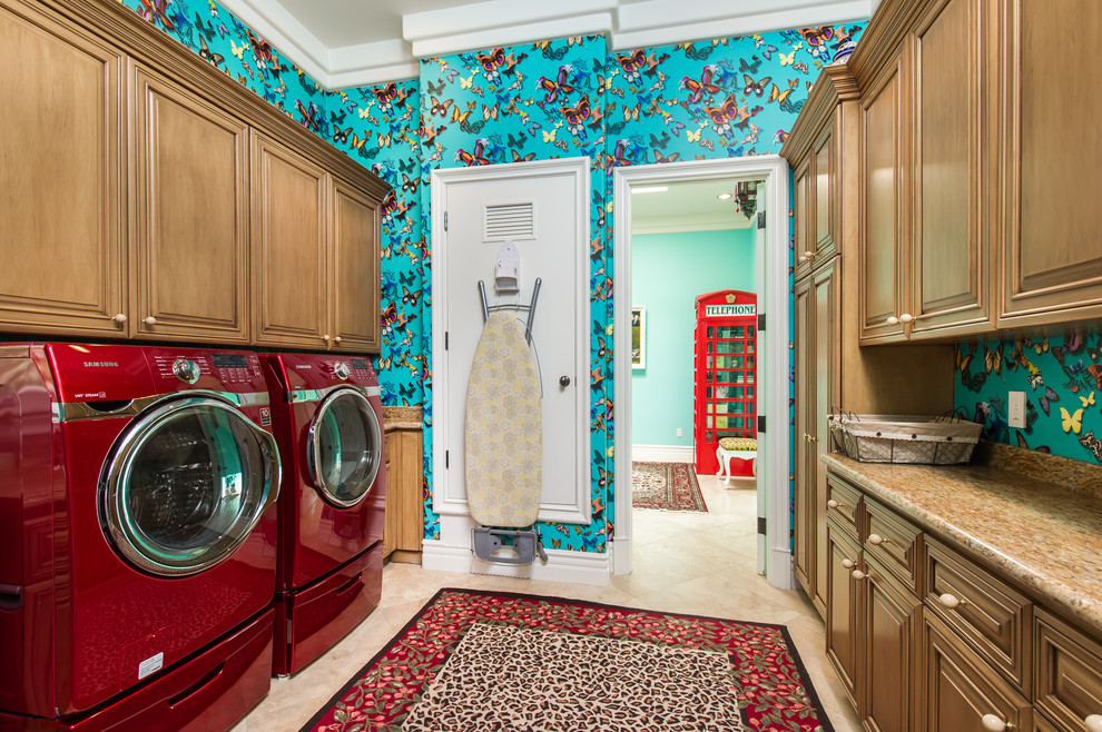 Mediterrane Waschküche mit profilierten Schrankfronten, hellbraunen Holzschränken, bunten Wänden, Waschmaschine und Trockner nebeneinander und beigem Boden in Los Angeles
