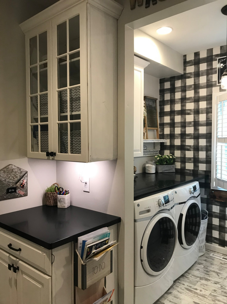 Foto på ett litet lantligt svart linjärt grovkök, med luckor med upphöjd panel, vita skåp, bänkskiva i koppar, flerfärgade väggar, vinylgolv, en tvättmaskin och torktumlare bredvid varandra och vitt golv