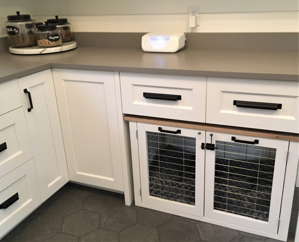 Photo of a medium sized country utility room in Minneapolis with a submerged sink, beaded cabinets, white cabinets, engineered stone countertops, white walls, ceramic flooring, a stacked washer and dryer, grey floors and grey worktops.