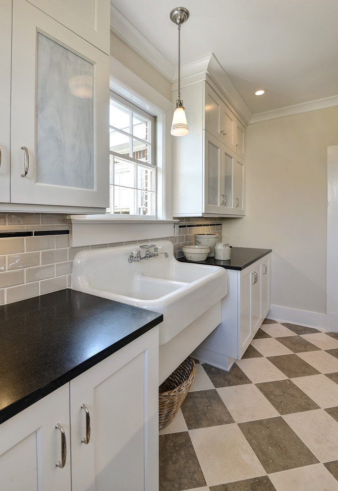 Inspiration for a large classic galley utility room in Charleston with an utility sink, recessed-panel cabinets, white cabinets, composite countertops, beige walls, a side by side washer and dryer, multi-coloured floors and black worktops.