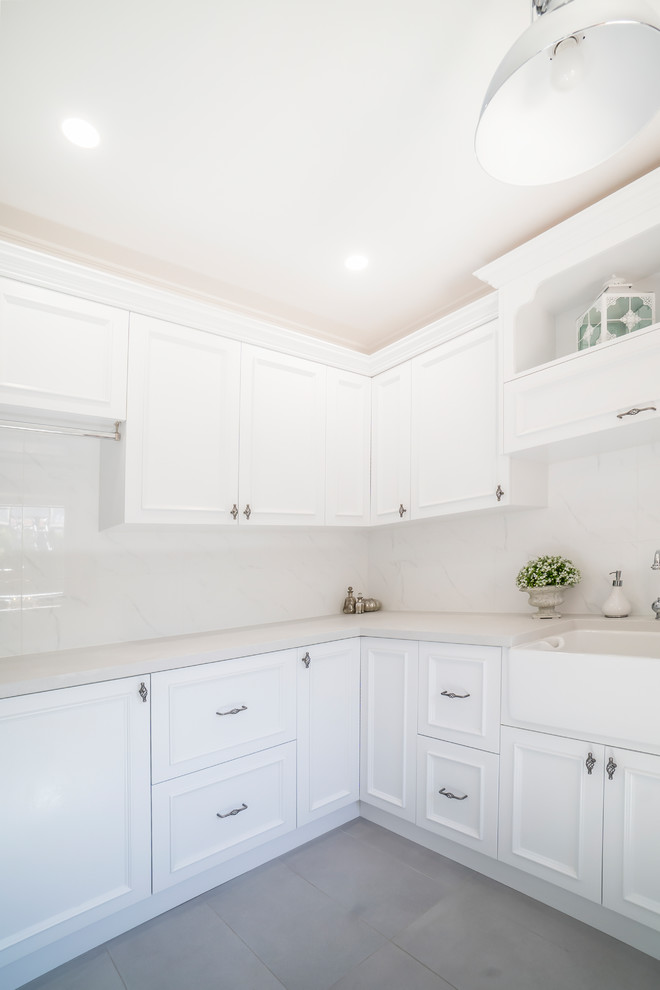 Laundry room - traditional u-shaped laundry room idea in Perth with a farmhouse sink, beaded inset cabinets, white cabinets, quartz countertops and gray countertops