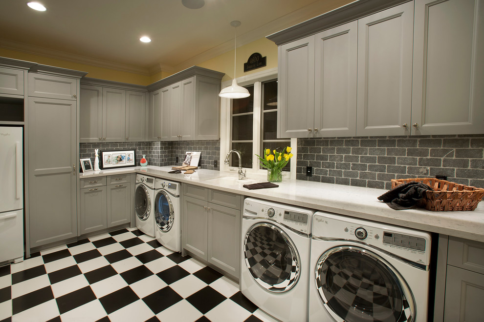 Esempio di una lavanderia classica con top in marmo, lavello sottopiano, ante con riquadro incassato, ante grigie, pareti gialle, lavatrice e asciugatrice affiancate e top bianco