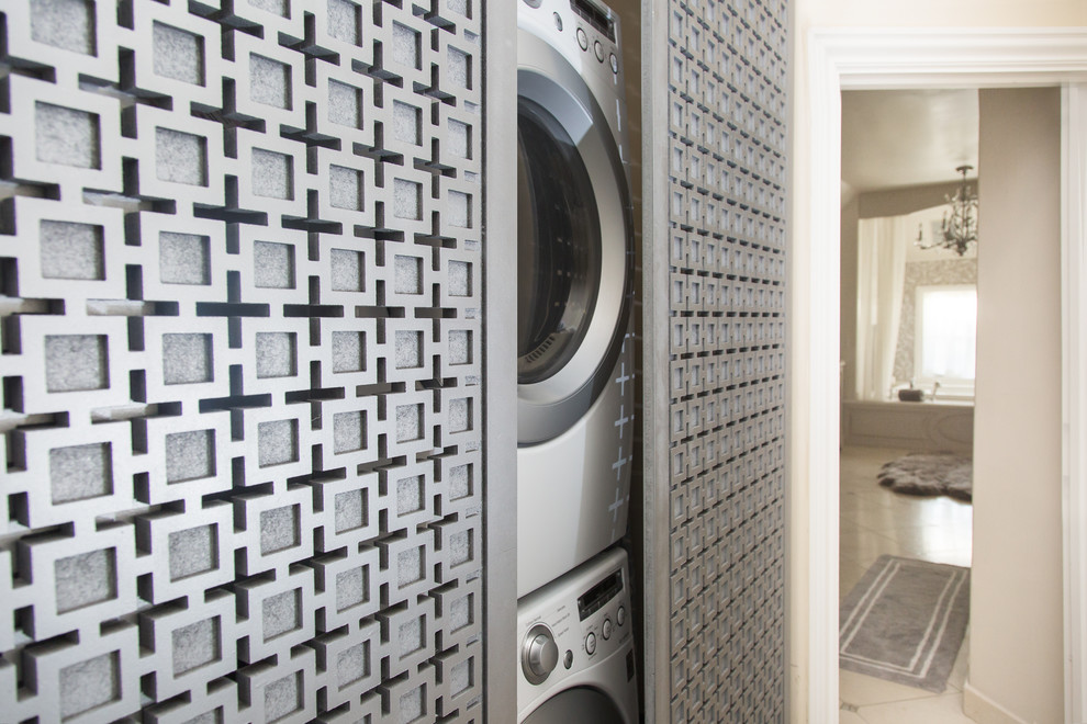 Imagen de armario lavadero actual pequeño con paredes beige y lavadora y secadora apiladas