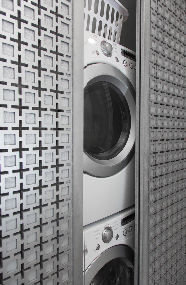 Immagine di un piccolo ripostiglio-lavanderia minimal con pareti beige e lavatrice e asciugatrice a colonna