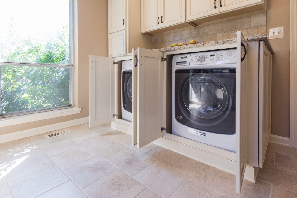 Exempel på en mellanstor klassisk parallell tvättstuga, med luckor med upphöjd panel, vita skåp, granitbänkskiva, beige stänkskydd, stänkskydd i porslinskakel och klinkergolv i porslin