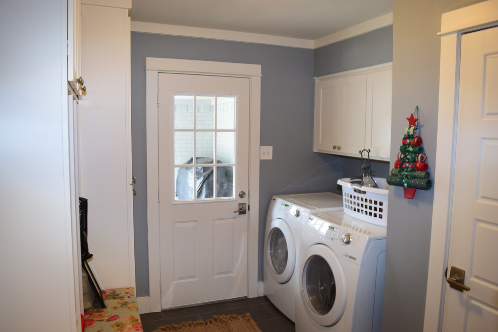 Cette photo montre une buanderie parallèle chic avec un placard à porte shaker, des portes de placard blanches, un mur bleu, un sol en carrelage de porcelaine et des machines côte à côte.