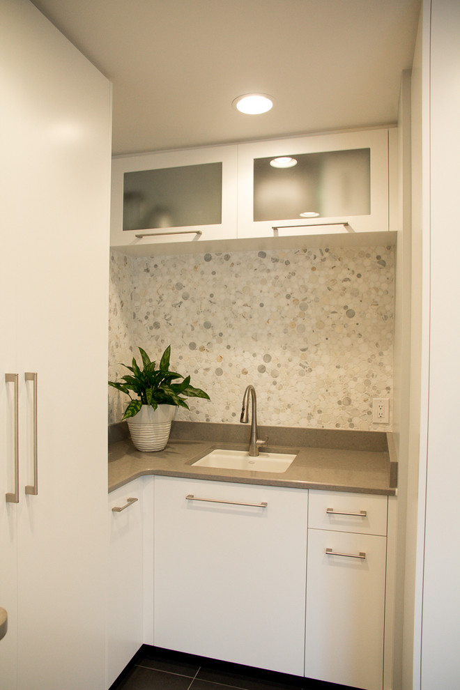Photo of a large contemporary u-shaped utility room in Tampa with a submerged sink, white cabinets, quartz worktops, grey walls, ceramic flooring, a side by side washer and dryer and flat-panel cabinets.