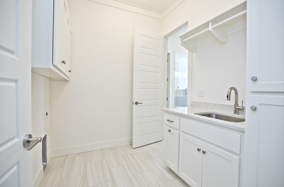 Idéer för mellanstora funkis parallella grått tvättstugor enbart för tvätt, med en undermonterad diskho, skåp i shakerstil, vita skåp, bänkskiva i kvarts, vita väggar, klinkergolv i porslin, en tvättmaskin och torktumlare bredvid varandra och beiget golv