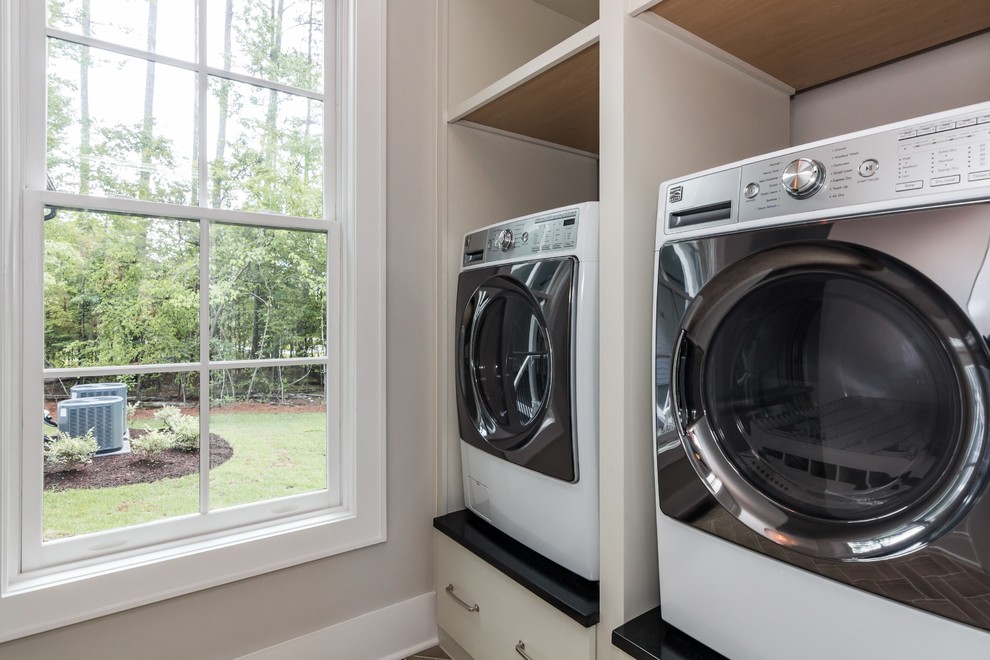 Mid-sized cottage single-wall ceramic tile dedicated laundry room photo in Raleigh with flat-panel cabinets, white cabinets, granite countertops, gray walls and a side-by-side washer/dryer