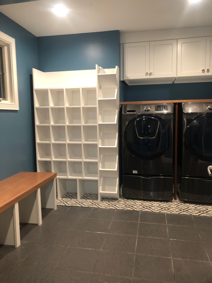 Ejemplo de lavadero multiusos y lineal ecléctico con armarios estilo shaker, puertas de armario blancas, encimera de madera, paredes azules, suelo de baldosas de cerámica, lavadora y secadora juntas y suelo gris