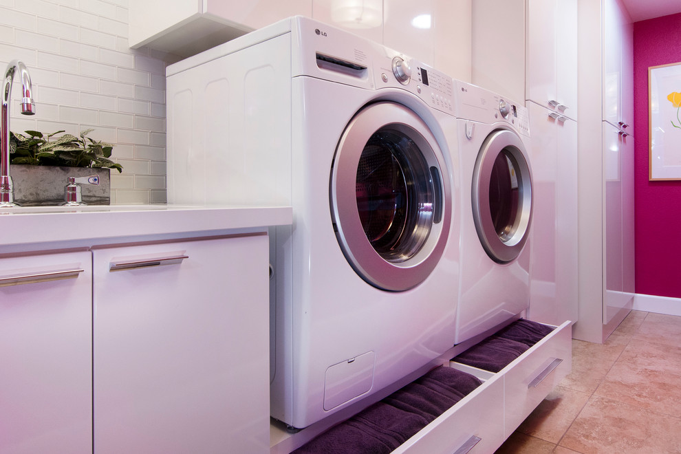 Immagine di una grande lavanderia multiuso minimal con lavello sottopiano, ante lisce, ante bianche, top in quarzo composito, pareti rosa, pavimento in gres porcellanato e lavatrice e asciugatrice affiancate