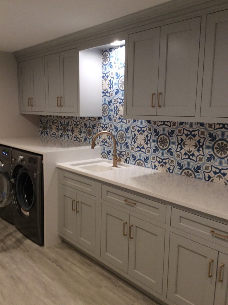 Laundry room - large mediterranean vinyl floor laundry room idea in Baltimore with an undermount sink, shaker cabinets, gray cabinets, quartz countertops, a side-by-side washer/dryer and white countertops