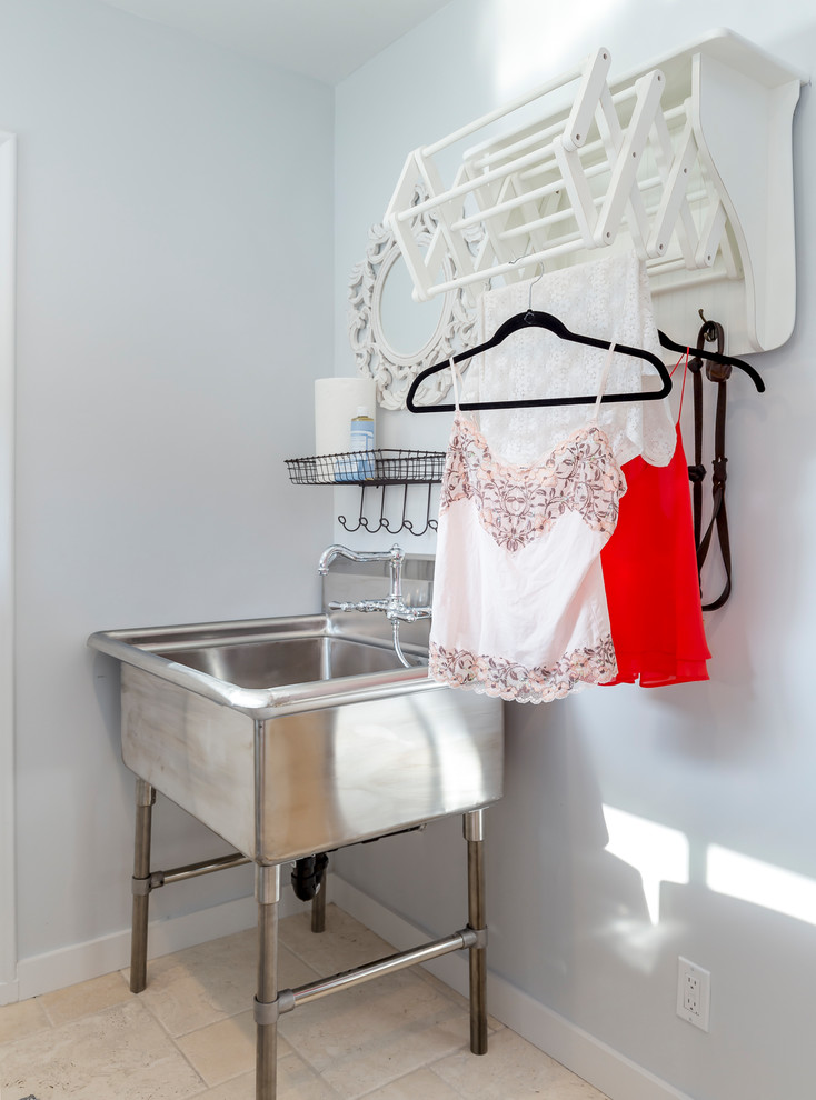 Idéer för små vintage tvättstugor enbart för tvätt, med en allbänk, vita väggar, en tvättmaskin och torktumlare bredvid varandra, vita skåp, travertin golv och luckor med infälld panel