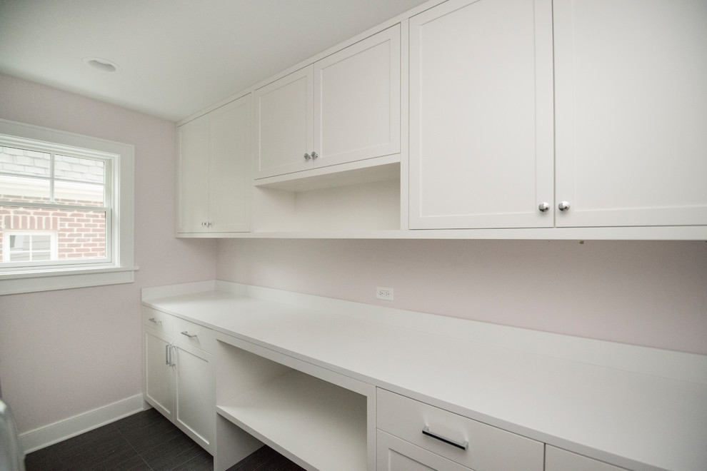 Medium sized traditional galley utility room in Chicago with shaker cabinets, white cabinets, engineered stone countertops, pink walls, slate flooring, a side by side washer and dryer and grey floors.