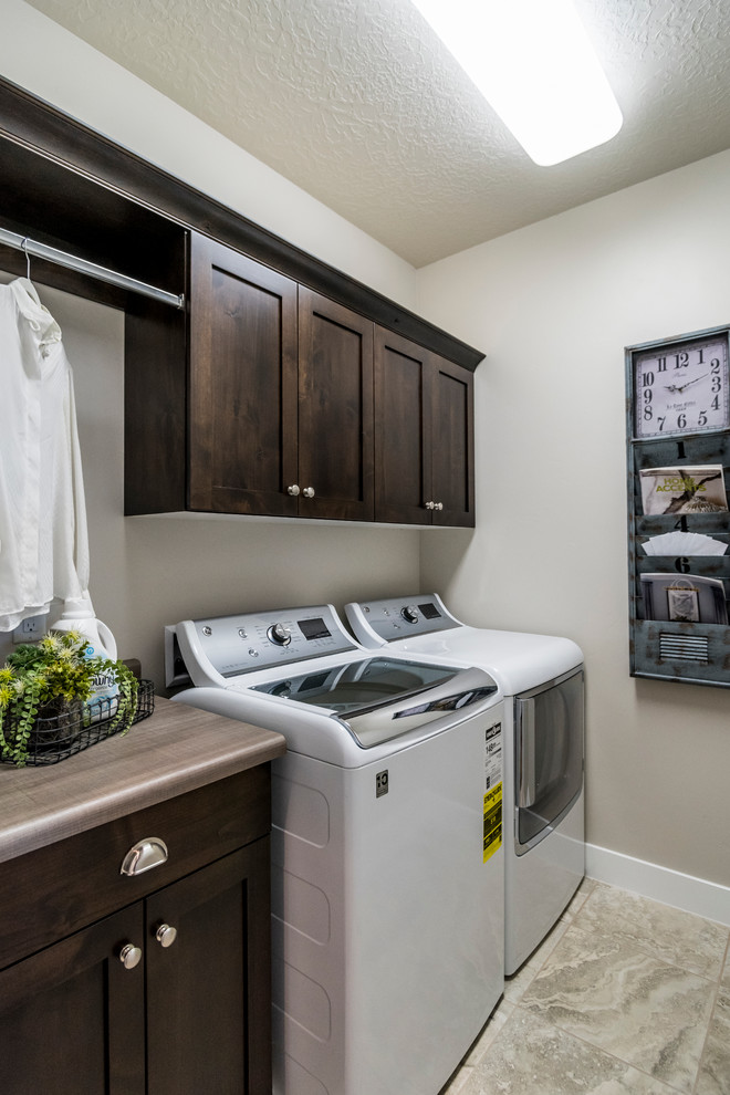 Diseño de cuarto de lavado lineal contemporáneo pequeño con armarios estilo shaker, puertas de armario de madera en tonos medios, suelo de baldosas de cerámica, lavadora y secadora juntas y paredes grises