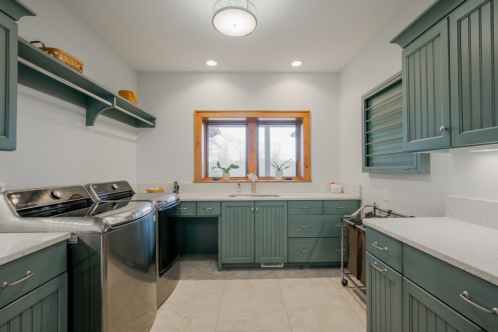 Example of a large mountain style u-shaped porcelain tile and beige floor dedicated laundry room design in Cleveland with a single-bowl sink, recessed-panel cabinets, blue cabinets, quartz countertops, white walls, a side-by-side washer/dryer and white countertops