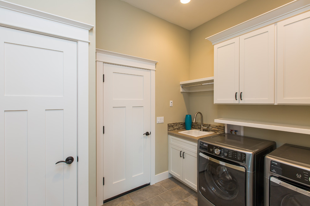 Example of a large trendy galley ceramic tile dedicated laundry room design in Portland with shaker cabinets, quartz countertops, a side-by-side washer/dryer, white cabinets, a drop-in sink and beige walls