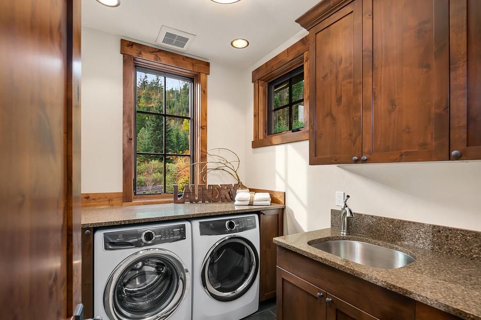 Example of a mountain style dedicated laundry room design in Seattle with a single-bowl sink, shaker cabinets, dark wood cabinets, granite countertops, white walls and a side-by-side washer/dryer