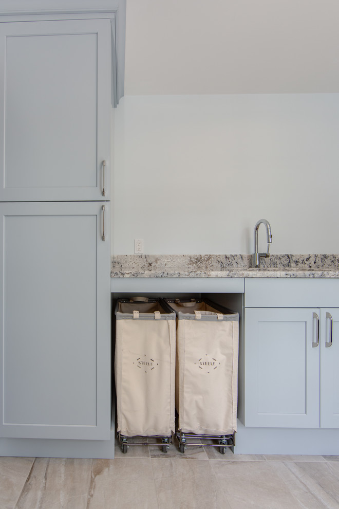 Inspiration for a mid-sized l-shaped porcelain tile and gray floor dedicated laundry room remodel in Boston with an undermount sink, shaker cabinets, blue cabinets, granite countertops, gray walls and a side-by-side washer/dryer