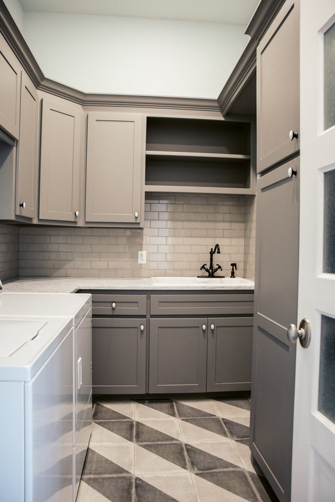 Design ideas for a mid-sized transitional u-shaped dedicated laundry room in Dallas with a drop-in sink, shaker cabinets, grey cabinets, quartzite benchtops, white walls, ceramic floors, a side-by-side washer and dryer and multi-coloured floor.