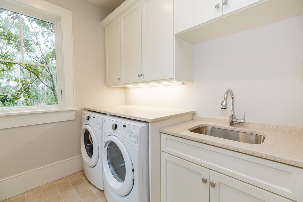 Example of a mid-sized beach style galley ceramic tile and beige floor laundry room design in Charleston with an undermount sink, shaker cabinets, white cabinets, quartz countertops, a side-by-side washer/dryer, beige countertops and gray walls