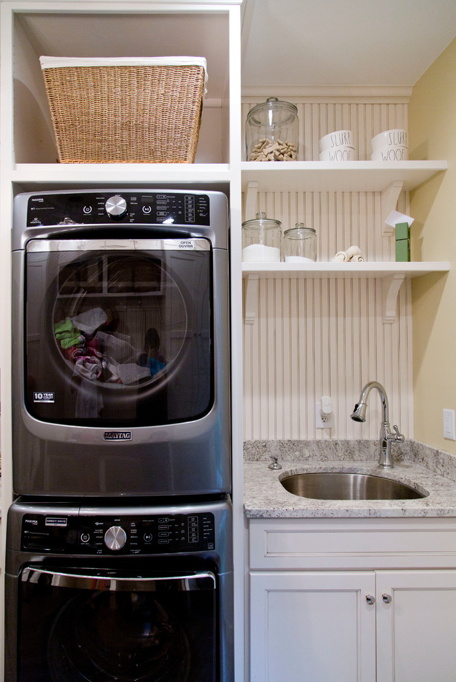 セントルイスにある高級な中くらいなトランジショナルスタイルのおしゃれな家事室 (I型、ドロップインシンク、落し込みパネル扉のキャビネット、白いキャビネット、御影石カウンター、黄色い壁、淡色無垢フローリング、上下配置の洗濯機・乾燥機) の写真