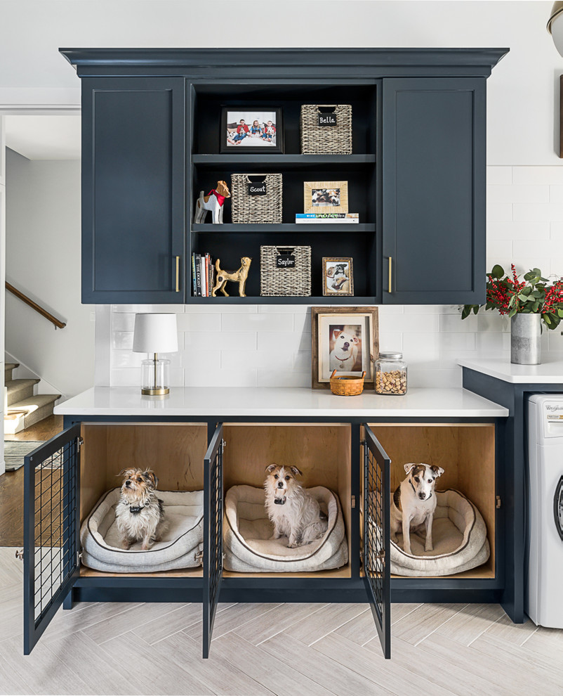 Cette image montre une buanderie rustique multi-usage avec un placard à porte shaker, des portes de placard bleues, un mur blanc et un sol beige.