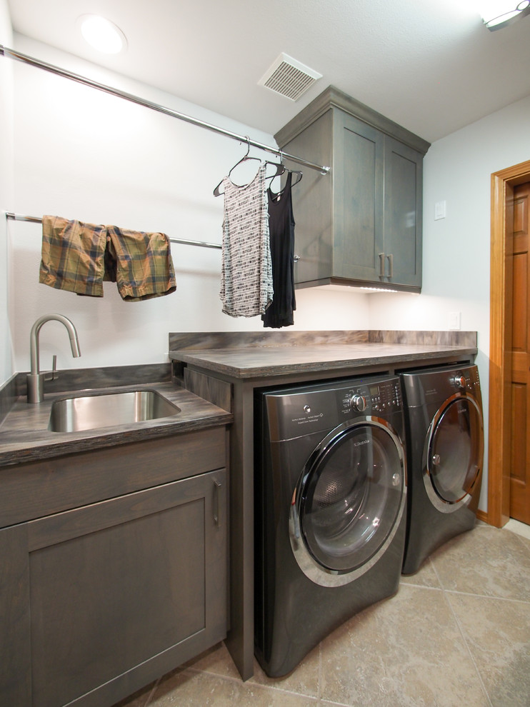 Inspiration for a medium sized classic galley separated utility room in Seattle with a submerged sink, recessed-panel cabinets, dark wood cabinets, composite countertops, blue walls, porcelain flooring, a side by side washer and dryer, brown splashback, beige floors and brown worktops.