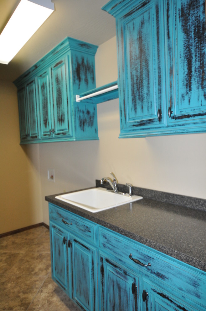 Photo of a large classic galley separated utility room in Oklahoma City with an utility sink, raised-panel cabinets, blue cabinets, laminate countertops, marble flooring, a side by side washer and dryer and beige walls.