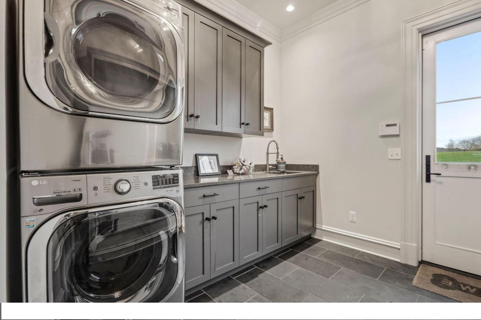 Medium sized classic single-wall separated utility room in DC Metro with a submerged sink, shaker cabinets, grey cabinets, engineered stone countertops, white walls, porcelain flooring, a stacked washer and dryer and grey worktops.