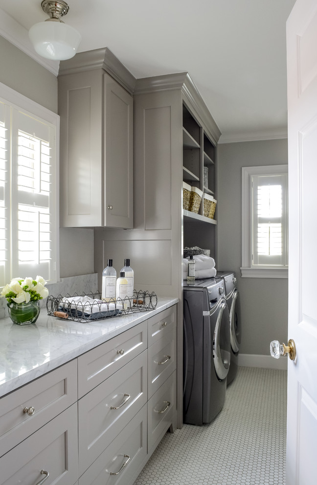 Bild på en mellanstor vintage vita vitt tvättstuga enbart för tvätt, med skåp i shakerstil, grå skåp, grå väggar, en tvättmaskin och torktumlare bredvid varandra, marmorbänkskiva, klinkergolv i keramik och vitt golv