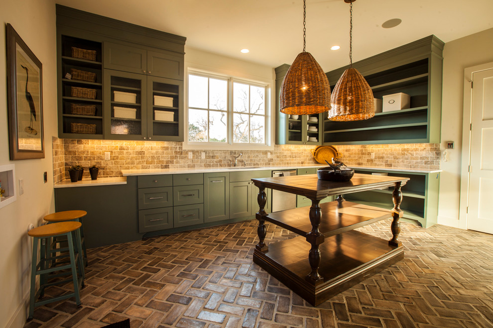 Traditional utility room in Austin with green cabinets and brown floors.