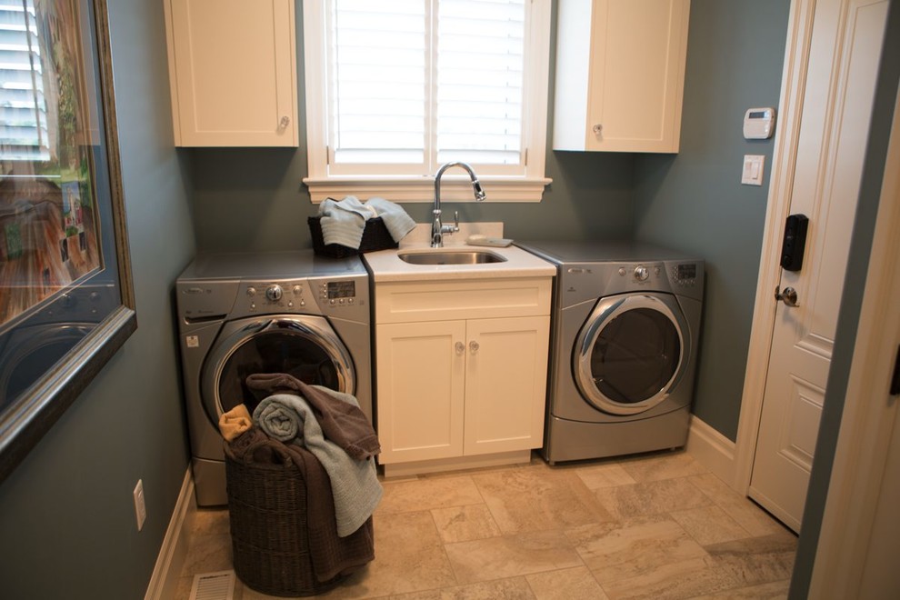 Idee per una sala lavanderia tradizionale di medie dimensioni con lavello da incasso, pareti blu, pavimento con piastrelle in ceramica e lavatrice e asciugatrice affiancate