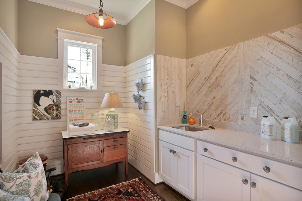 Bild på en mellanstor amerikansk linjär tvättstuga enbart för tvätt, med luckor med infälld panel, vita skåp, beige väggar, mörkt trägolv och en undermonterad diskho