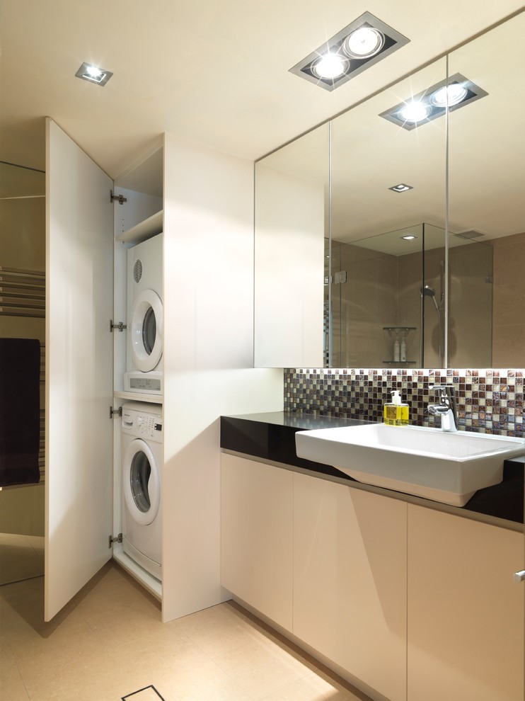 Immagine di una lavanderia multiuso contemporanea di medie dimensioni con ante lisce, ante bianche e lavatrice e asciugatrice a colonna