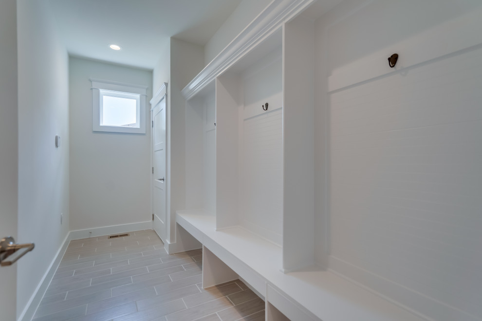 Imagen de armario lavadero clásico renovado grande con paredes blancas, suelo de baldosas de cerámica y suelo gris