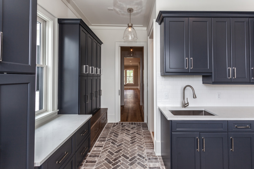 Huge beach style l-shaped brick floor utility room photo in Charleston with an undermount sink, beaded inset cabinets, blue cabinets, quartz countertops, white backsplash, subway tile backsplash, white walls, a side-by-side washer/dryer and white countertops